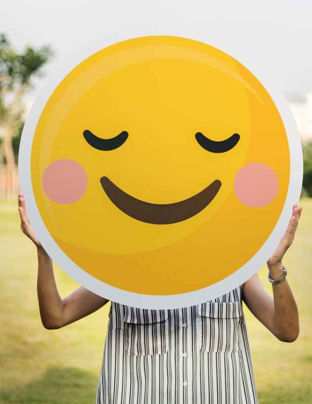 person holding round smiling emoji board photo
